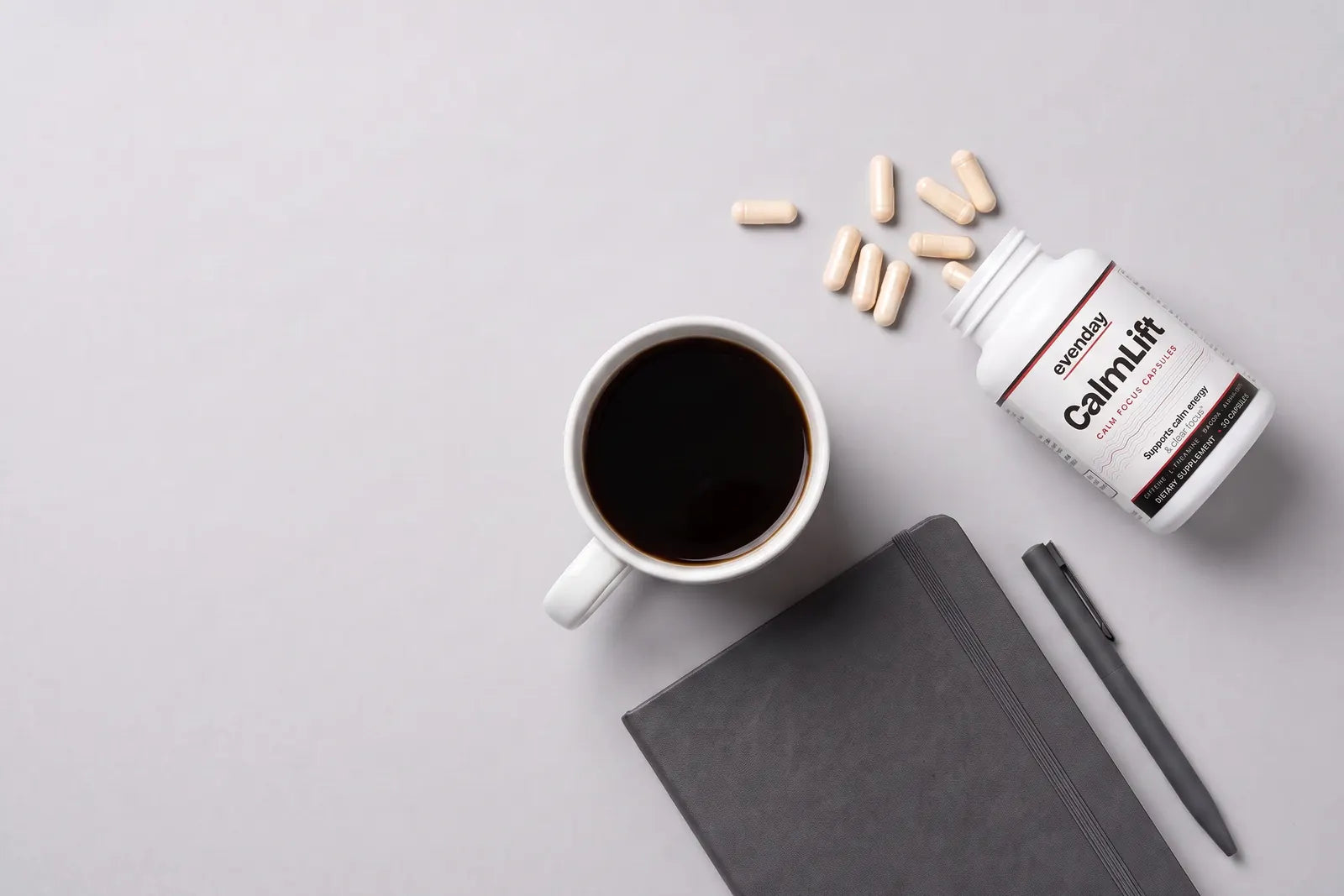 CalmLift bottle with capsules, a coffee and a notebook